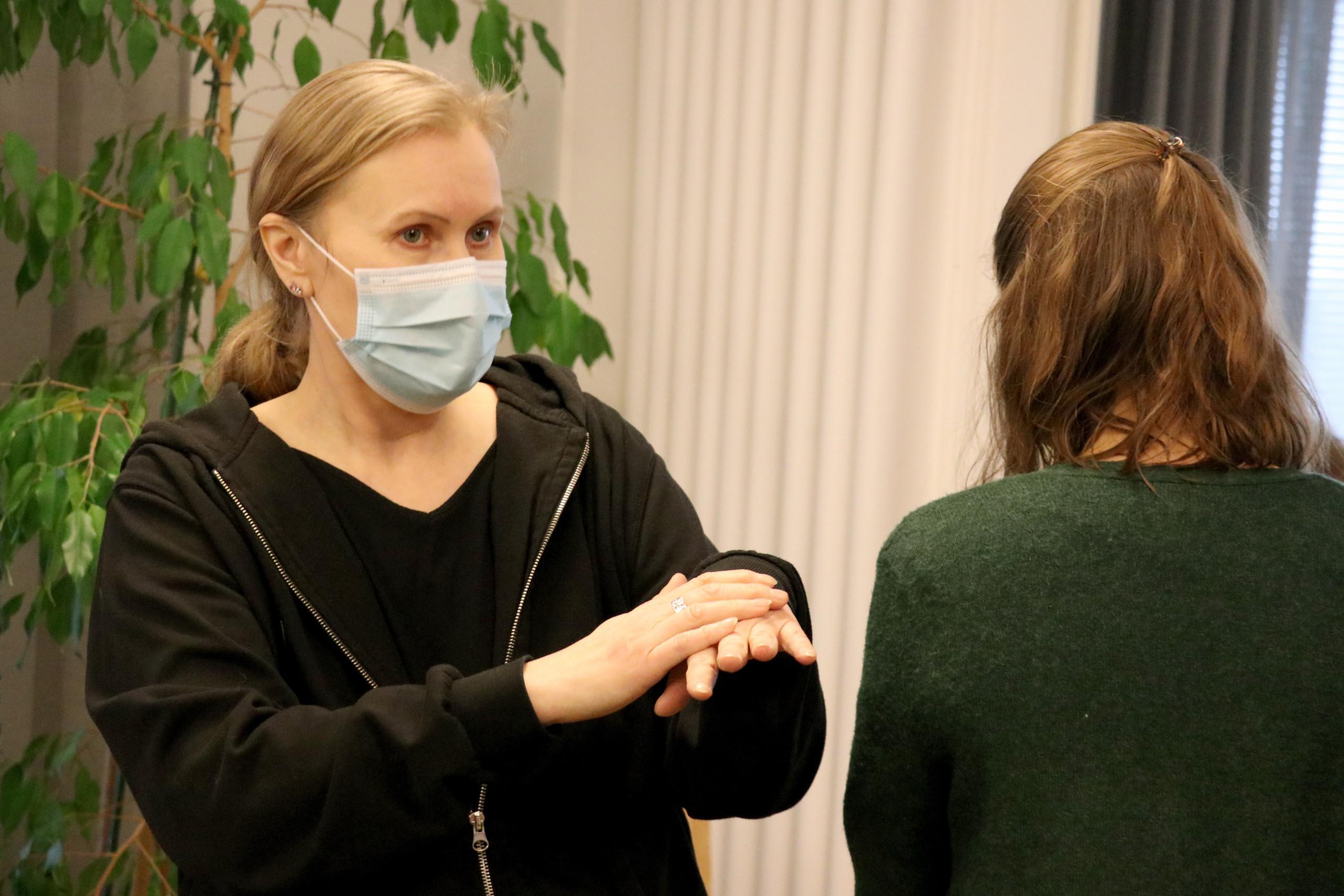 Opetus ja koulutus -alasivulle. Kouluttaja näyttää viittomia.